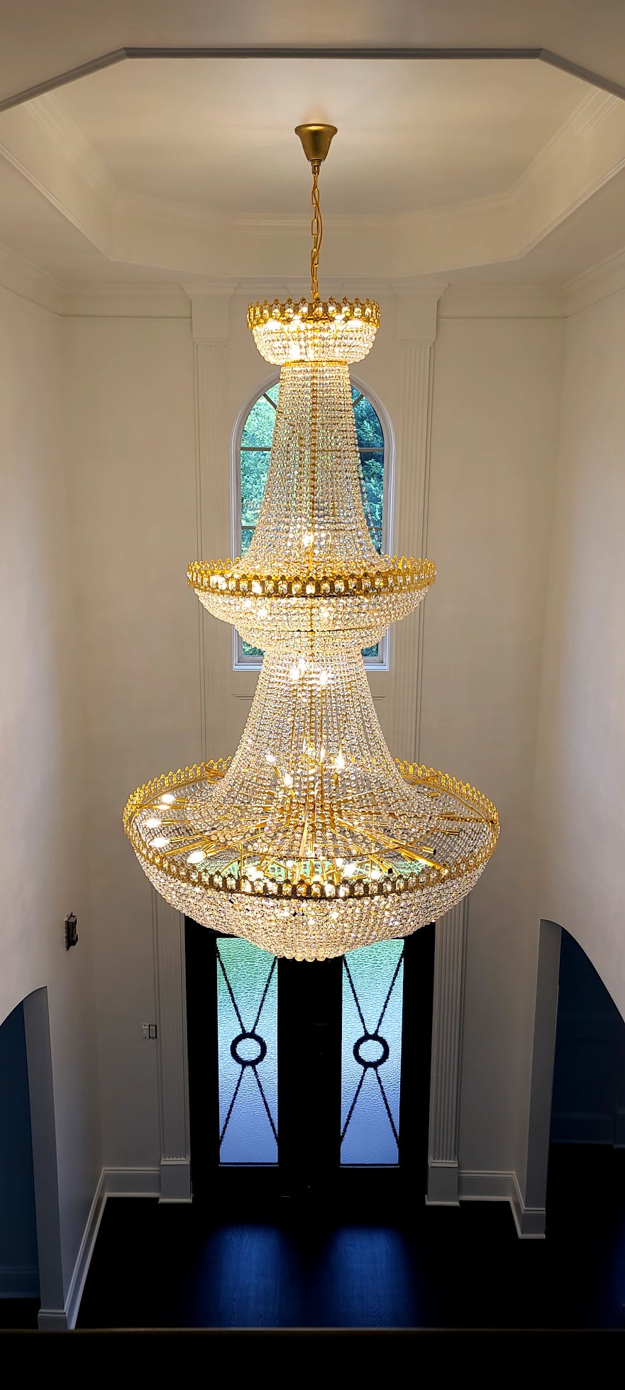 Modern chandelier installation with high ceiling access