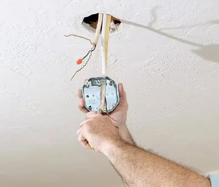 Old ceiling electrical box being replaced for chandelier installation in Atlanta