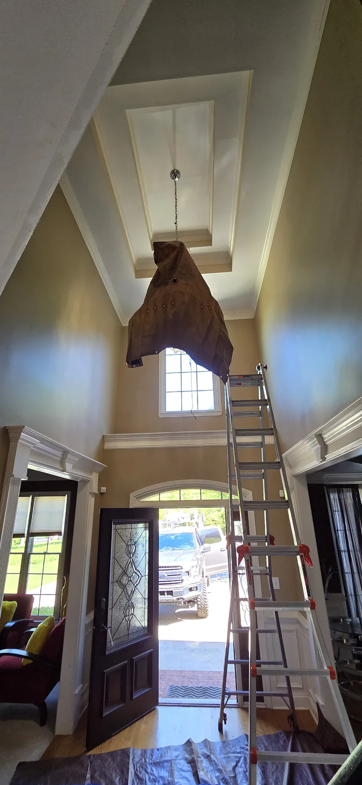 Foyer chandelier installation with high-ceiling access in Atlanta
