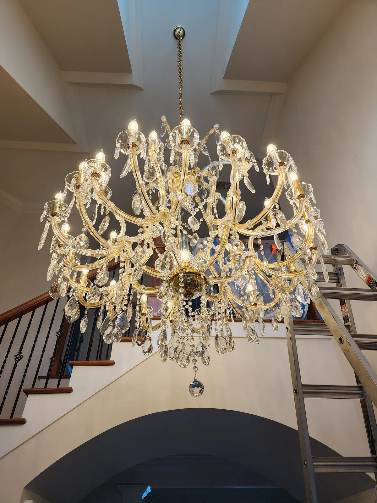 High-ceiling foyer chandelier installation with ladder work in Atlanta