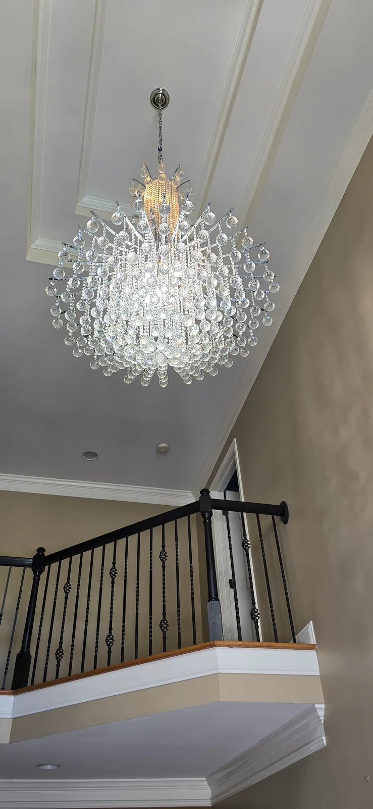 Large foyer chandelier installed in a high-ceiling Atlanta entryway