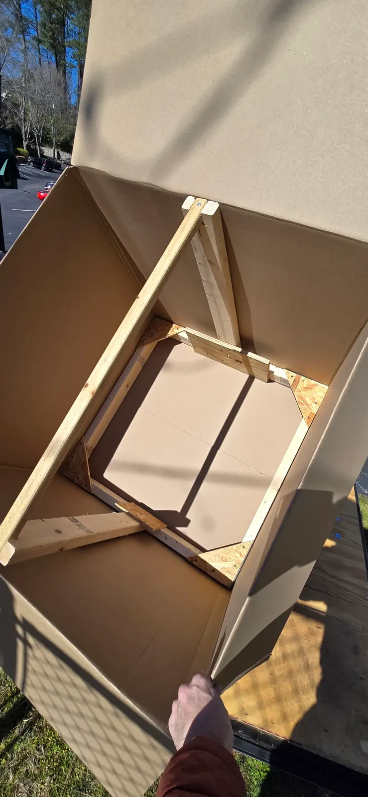 Chandelier hanging inside a storage box with a support frame for safer transport
