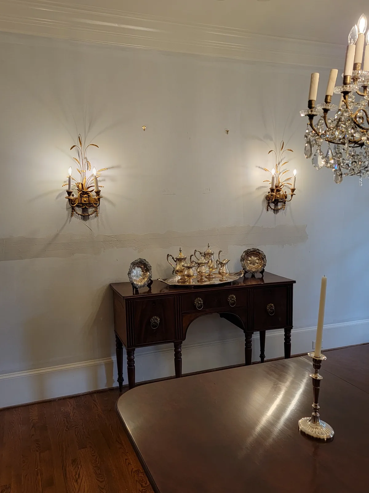 Dining room chandelier and wall sconces installed in a traditional Atlanta home