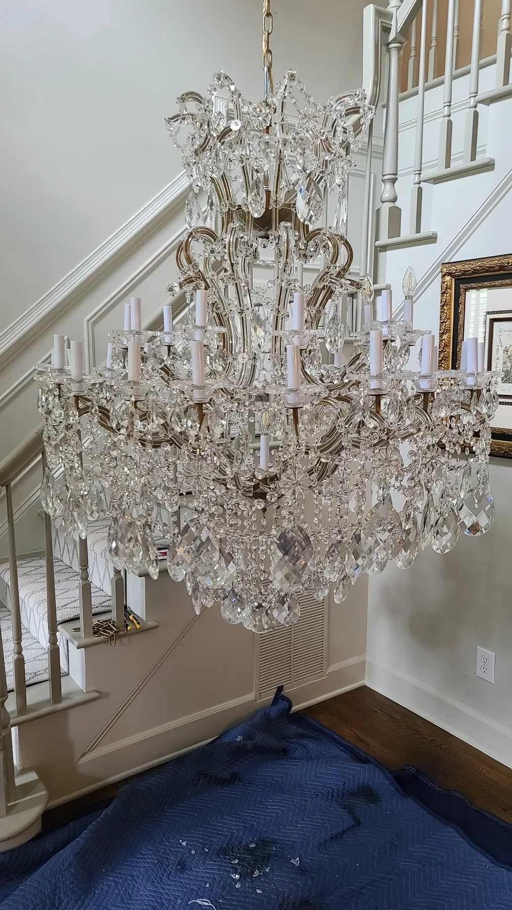 Large traditional crystal chandelier installed above a staircase in Atlanta