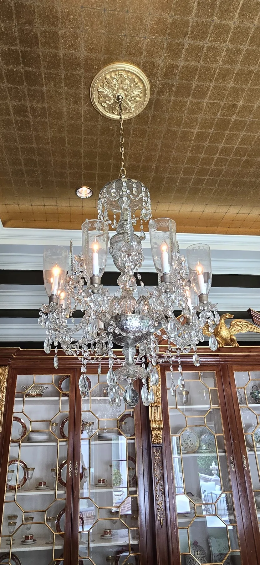 Traditional antique chandelier with spear-shaped crystal elements in a dining room