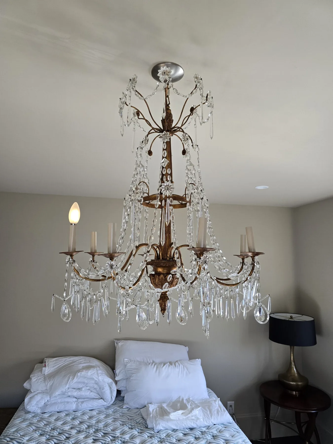 Traditional metal and glass chandelier installed in a bedroom